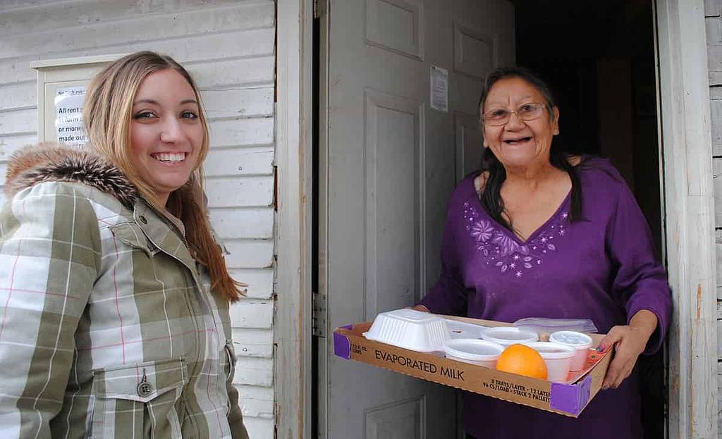 volunteer delivering meal to senior