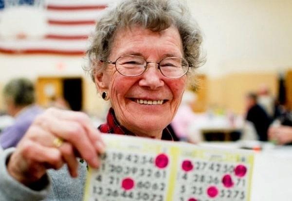 senior holding up a winning bingo card